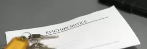 House keys sitting on an eviction notice received in the mail.