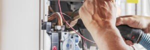 mechanic repairing gas boiler with a wrench