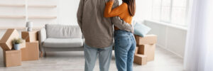 young couple hugging in apartment full of boxes